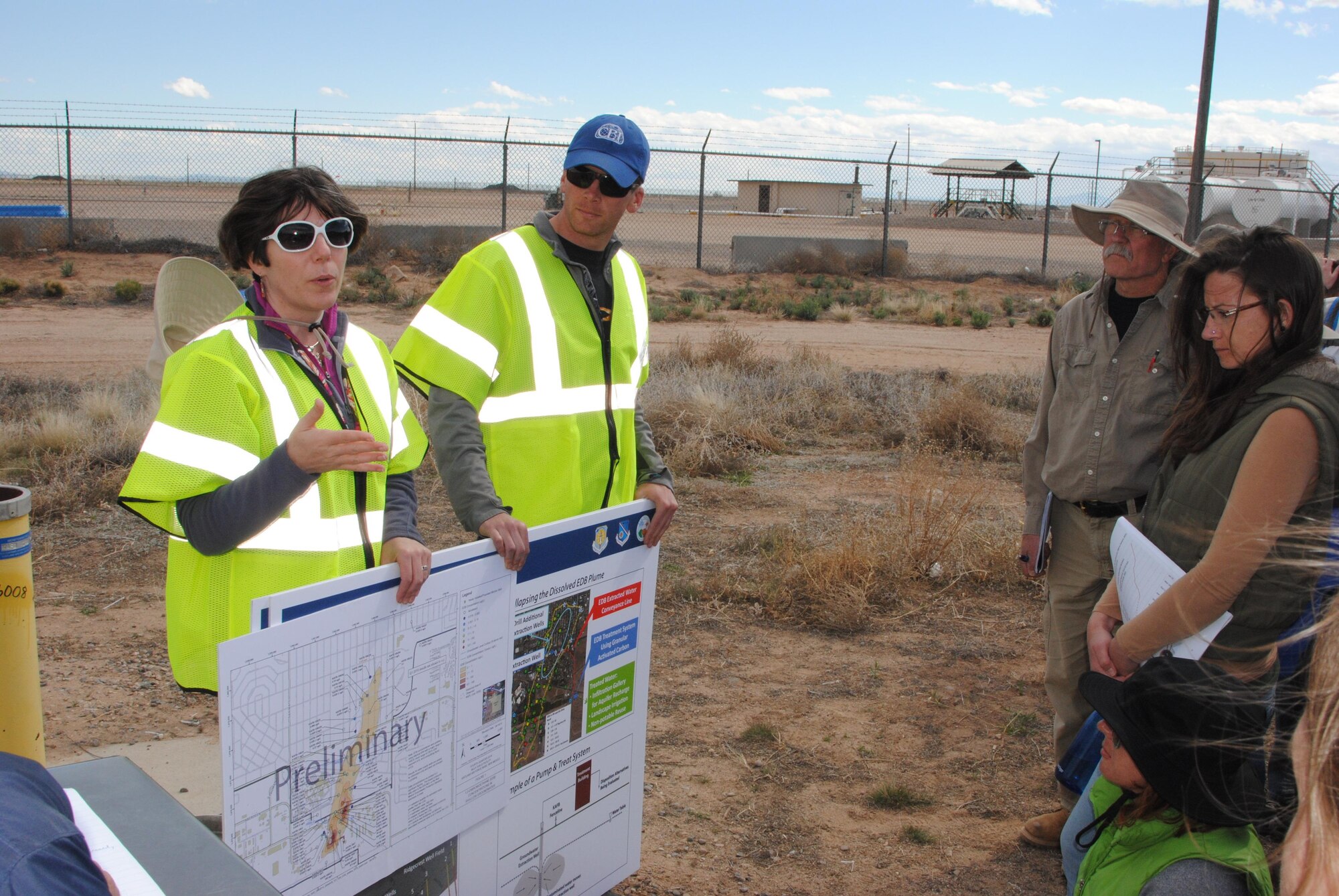 From left, project lead scientist Dr. Adria Bodour, a member of the Air Force Civil Engineer Center, and Jason Tarbert, with environmental contractor CB&I, discuss migration of the contamination plume and recent positive results from monitoring wells with members of the public April 18 near Kirtland's Bulk Fuels Facility. The discussion was part of a field trip to give members of the community an in-depth look at the science behind remediation efforts. (U.S. Air Force Photo/Jim Fisher/Released)