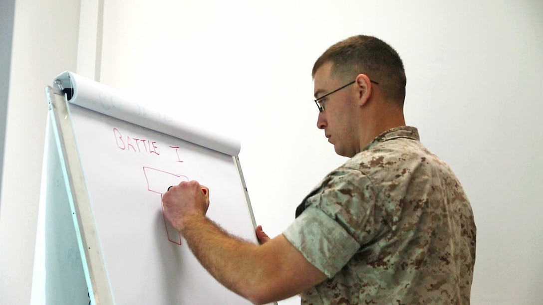 U.S. Marine Staff Sgt. Joseph Finn with Black Sea Rotational Force draws the ‘Battle I’ formation as an option to set-up the combat operations center during a military-to-military engagement at Camp Adem Jashari in Pristina, Kosovo, April 14-24, 2015. The command and control and combat operations center workshops ended with applying the information gained from the discussions into a practical application Command Post Exercise scenario.