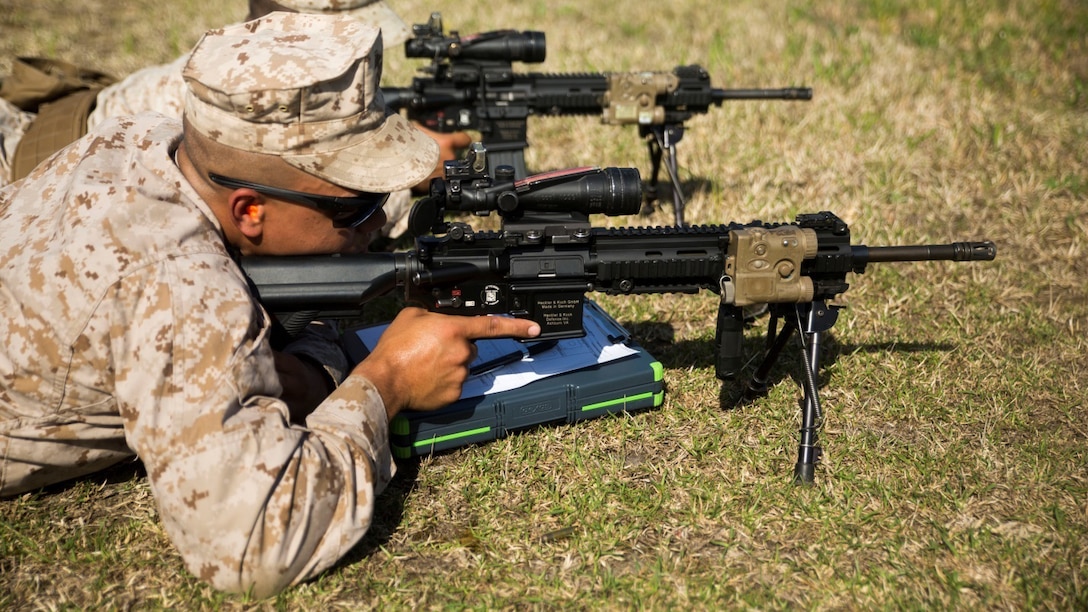 Two Marines from 3rd Battalion, 8th Marine Regiment, sight in on their targets during a Designated Marksman Course with the Division Combat Skills Center, April 6-17, 2015, aboard Camp Lejeune, N.C. The Marines learned range calls, wind estimation, and other basics of long range marksmanship.