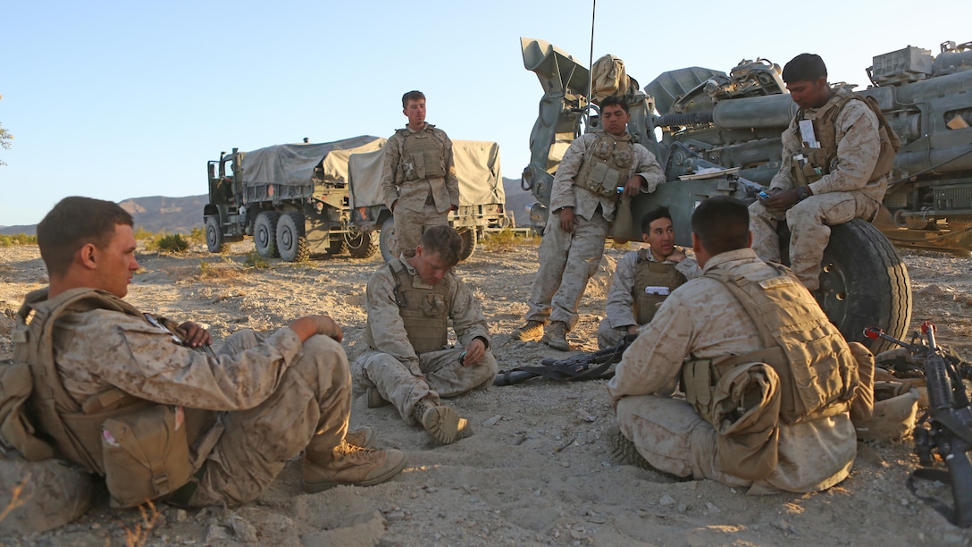 Marines with Battery A, 1st Battalion, 11th Marine Regiment, 1st Marine Division discuss the days training during Exercise Desert Scimitar 2015 aboard Marine Corps Air Ground Combat Center Twentynine Palms, Calif., April 20, 2015. The tough, realistic live-fire training central to Desert Scimitar allows Division units to train in order to maintain readiness and meet current and real-world operational demands.
