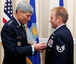 Air Force Chief of Staff Gen. Norton Schwartz hangs the bronze star with valor award on Staff Sgt. Kenneth I. Walker III during the Air Force Association's Air and Space Conference and Technology Exposition at the National Harbor in Oxon Hill, Md., Sept. 14, 2010.  Walker, a member of the Washington Air National Guard, earned the award for heroism as a member of Detachment 2, 817th Expeditionary Air Support Operations Squadron and Task Force Spader while engaged in ground combat in Ghosleck Valley, Afghanistan