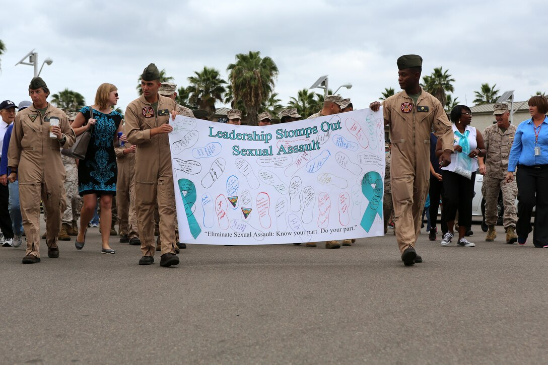 Participants in the Sexual Assault Awareness Month Walk aboard Marine Corps Air Station Miramar, California hold up a banner promoting sexual assault awareness on the air station, April 20. The annual walk encourages the prevention of sexual assault and related incidents on and off the instillation. (U.S. Marine Corps photo by Sgt. Melissa Wenger/Released)