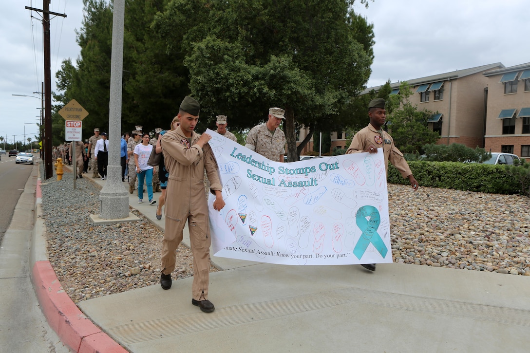 Participants in the Sexual Assault Awareness Month Walk aboard Marine Corps Air Station Miramar, California hold up a banner promoting sexual assault awareness on the air station, April 20. The annual walk encourages the prevention of sexual assault and related incidents on and off the instillation. (U.S. Marine Corps photo by Sgt. Melissa Wenger/Released)