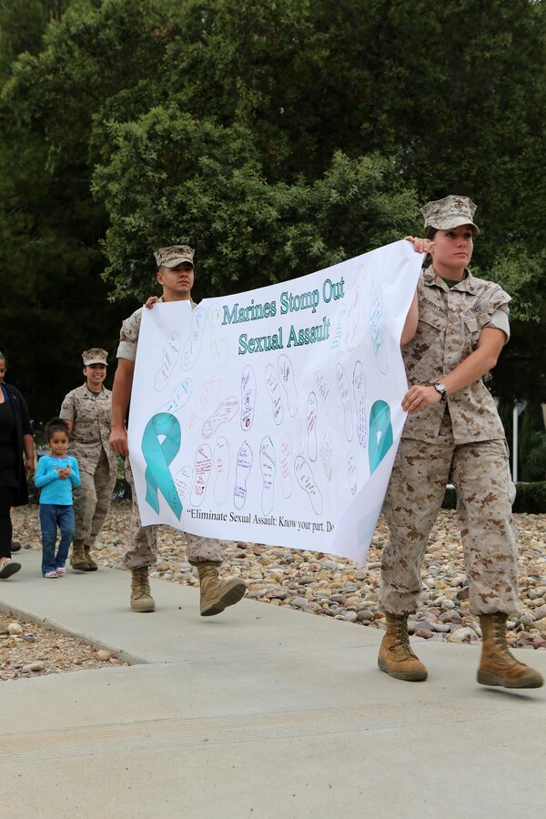 Participants in the Sexual Assault Awareness Month Walk aboard Marine Corps Air Station Miramar, California hold up a banner promoting sexual assault awareness on the air station, April 20. The annual walk encourages the prevention of sexual assault and related incidents on and off the instillation. (U. S. Marine Corps photo by Sgt. Melissa Wenger/Released)