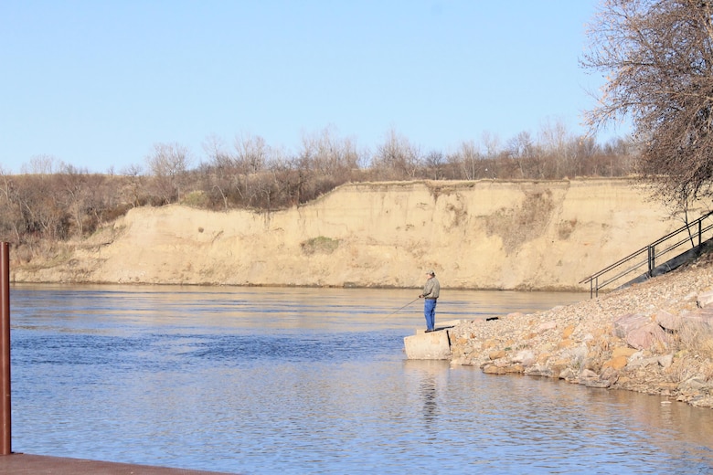 A visitor fishes from the shore near the downstream boat ramp at the Garrison Dam near Riverdale, North Dakota