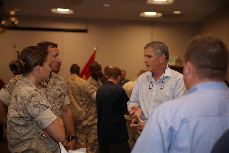 Elki Carpel, senior account manager, M2 Tecnology, explains new technologies to 1st Lt. Isis Culver and 1st Lt. Eric Becker, communication officers, 1st Tank Battalion, during the Tactical and Technology Day at the Officers’ Club, April 21, 2015. This event is held twice a year, in April and November. (Official Marine Corps photo by Lance Cpl. Thomas Mudd/Released)