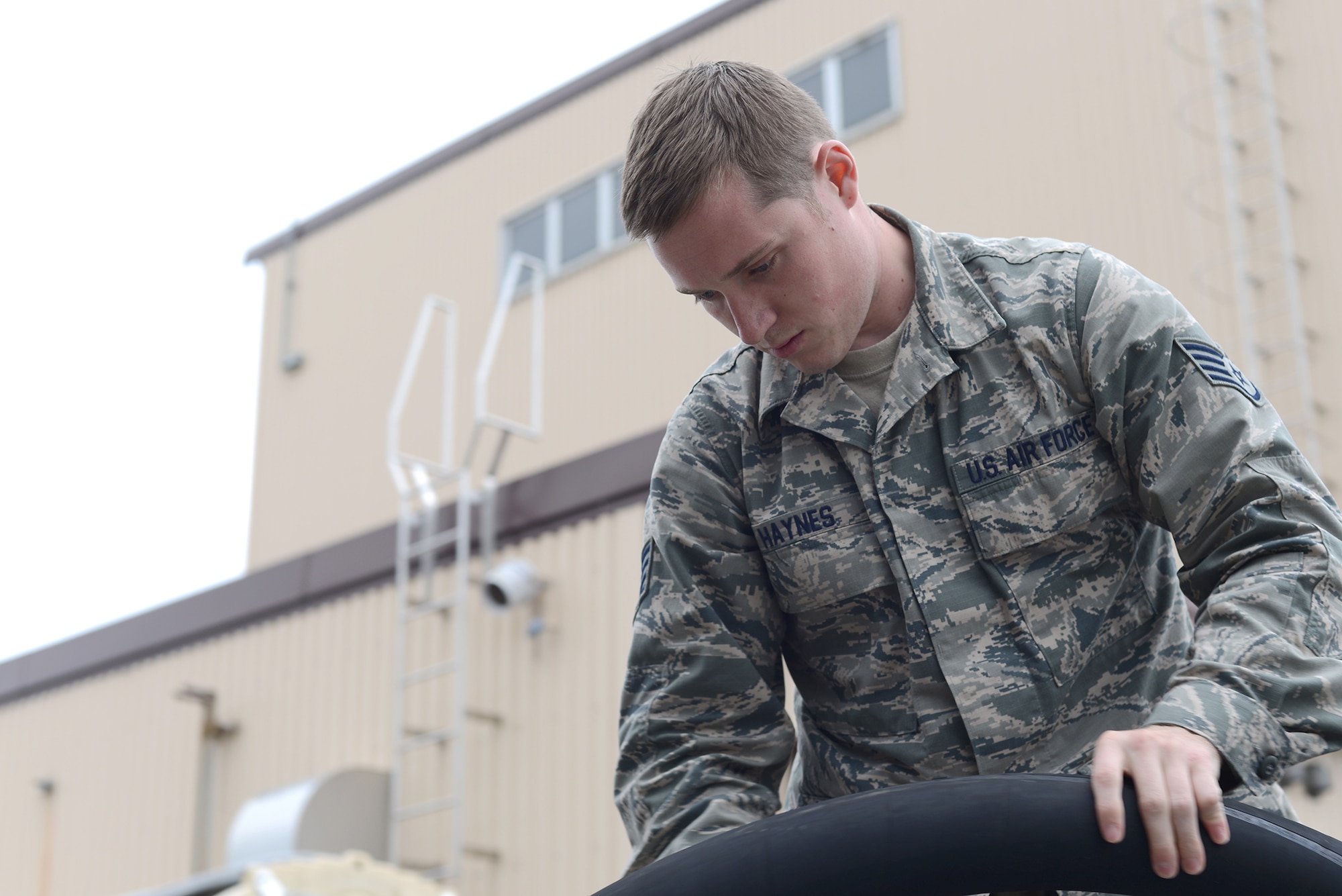 Staff Sgt. Jacob Haynes, 374th Logistics Readiness Squadron NCO in charge of fuels environmental safety office, checks the hose of an R-11 fuel truck for damage during a preventative maintenance inspection at Yokota Air Base, Japan, April 21, 2015. PMIs are performed daily when the vehicles are in use to ensure a safe working environment for the LRS Airmen. (U.S. Air Force photo by Airman 1st Class David C. Danford/Released)