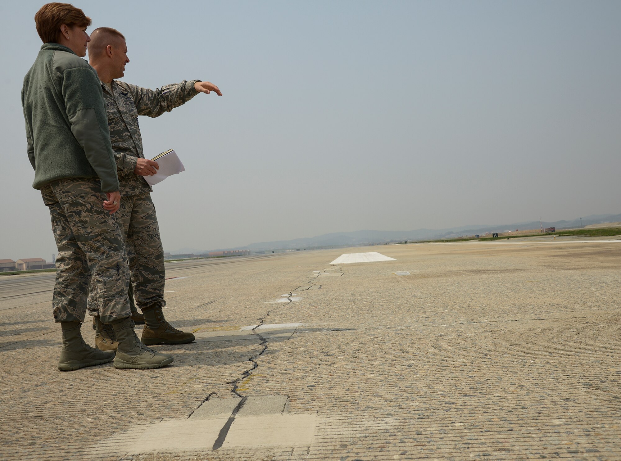 Gen. Lori Robinson, Pacific Air Forces commander, talks with Col. Brook Leonard, 51st Fighter Wing commander, about cracks in the runway during a briefing April 22, 2015, at Osan Air Base, Republic of Korea. Repairing and renovating the runway is the top key task for Team Osan. (U.S. Air Force photo by Staff Sgt. Jake Barreiro/Released)