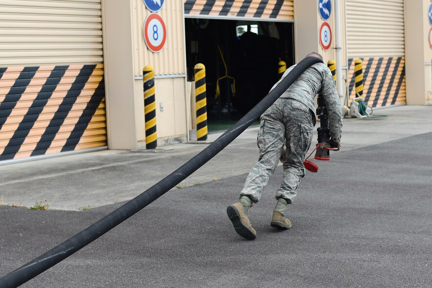 Staff Sgt. Daniel Greene, 374th Logistics Readiness Squadron fuel distribution supervisor, unrolls the hose of an R-11 fuel truck at Yokota Air Base, Japan, April 21, 2015. The hoses are checked regularly for cuts and abrasions to prevent fuel leaks. (U.S. Air Force photo by Airman 1st Class David C. Danford/Released)