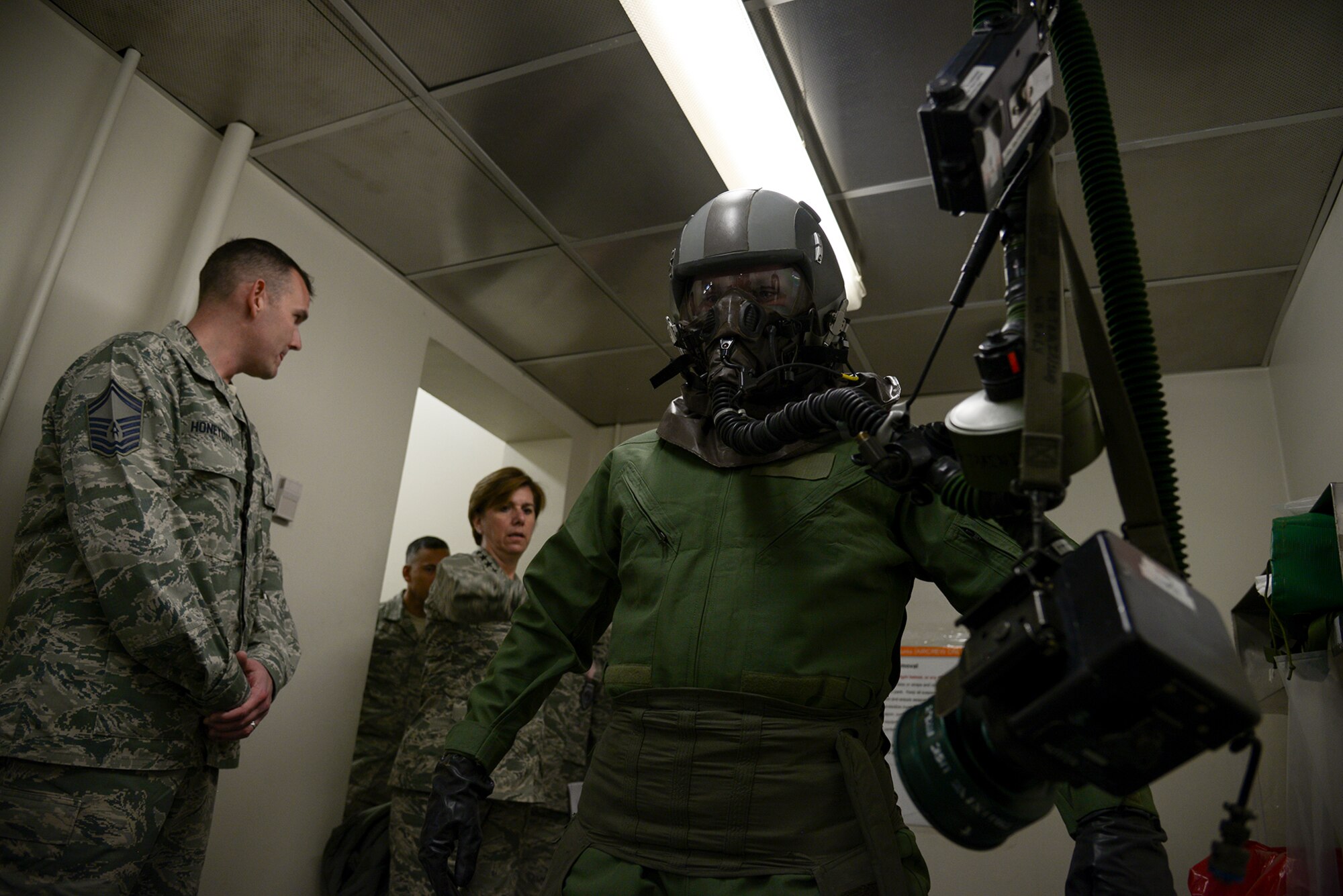 Gen. Lori Robinson, Pacific Air Forces commander, watches an Airman from the 25th Aircraft Maintenance Unit remove flight and decontamination gear during a demonstration April 22, 2015, at Osan Air Base, Republic of Korea. Robinson was visiting Osan AB for the second time since assuming command of PACAF. (U.S. Air Force photo by Staff Sgt. Jake Barreiro/Released)