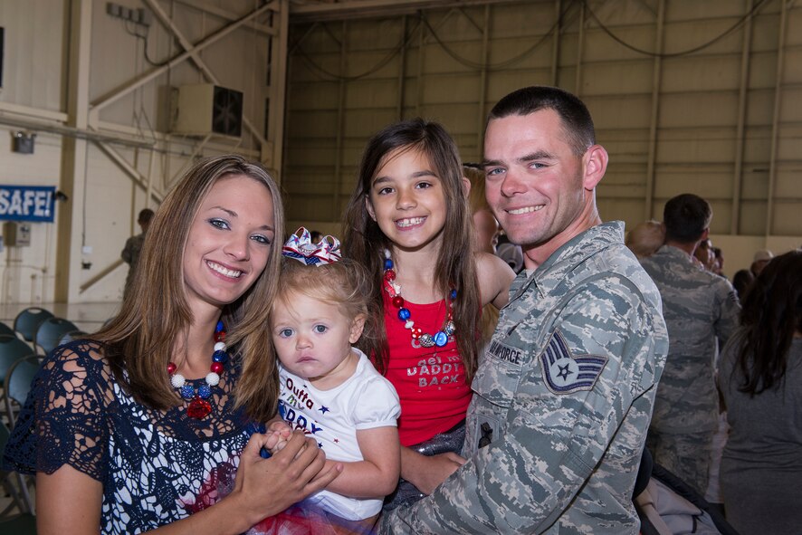 U.S. Air Force Staff Sgt. Brandon Deryke, 822nd Base Defense Squadron combat arms NCO in charge of combat arms, joins his family during the 822nd BDS deployment return April 21, 2015, at Moody Air Force Base, Ga. The 822nd BDS is a part of the 820th Base Defense Group which is the only global deployable, ‘first-in’ force protection unit. (U.S. Air Force photo by Airman Greg Nash/Released)