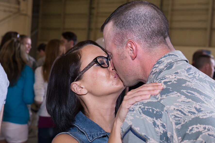 U.S. Air Force Master Sgt. Garret Brown, 822nd Base Defense Squadron flight sergeant, kisses his wife, Victoria, after returning from a six-month deployment April 21, 2015, at Moody Air Force Base, Ga. The 822nd BDS is a part of the 820th Base Defense Group which rotates on a cyclic deployment schedule approximately every six months. (U.S. Air Force photo by Airman Greg Nash/Released) 