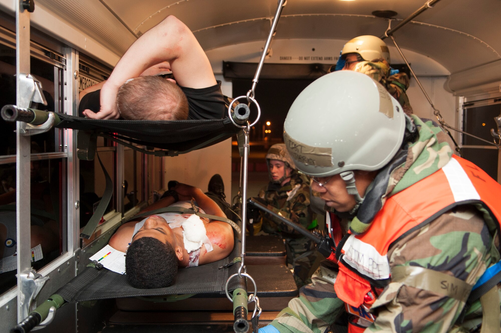 Simulated casualties lie strapped into a medical transport bus as Airmen with the 18th Medical Group prepare to move them to the hospital during Exercise Beverly High 15-2 on Kadena Air Base, Japan, April 22, 2015. Airmen are graded on their procedures and actions during the simulation. (U.S. Air Force photo/Senior Airman Omari Bernard))