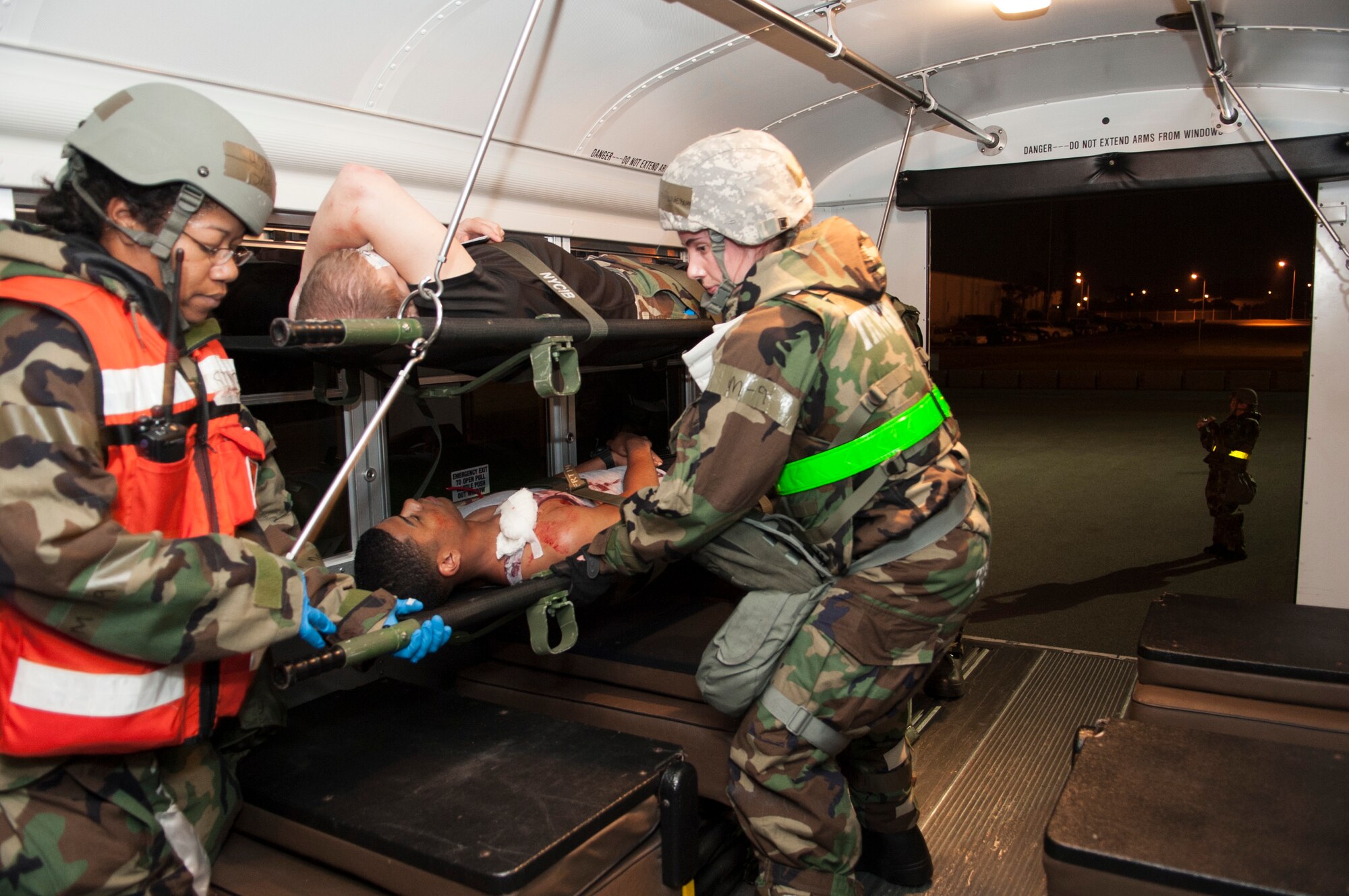 Airmen with the 18th Medical Group secure a simulated casualty of an active shooter scenario onto the rack of a medical transport bus during Exercise Beverly High 15-2 on Kadena Air Base, Japan, April 22, 2015. Exercise BH 15-2 allows Airmen to train and make mistakes in a low-risk environment in which they can become more confident in their ability to perform under pressure. (U.S. Air Force photo/Senior Airman Omari Bernard)