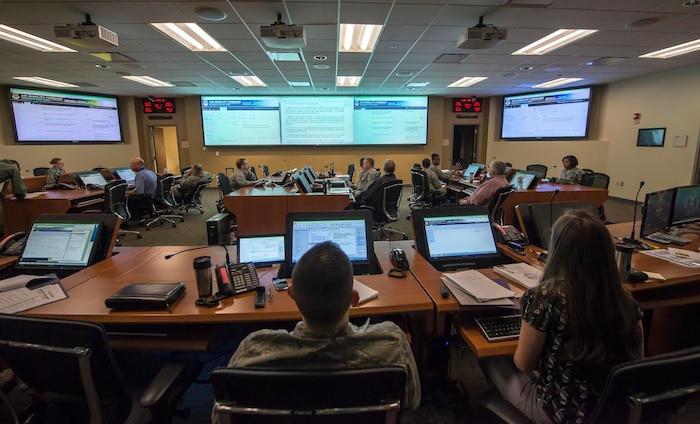 Squadron Airmen and civilians man the Emergency Operations Center April 21, 2015, at Joint Base Charleston, S.C., during a Hurricane Exercise. The EOC is a centralized command and control facility responsible for providing strategic decisions during disasters or emergencies. (U.S. Air Force illustration/Senior Airman Jared Trimarchi)  