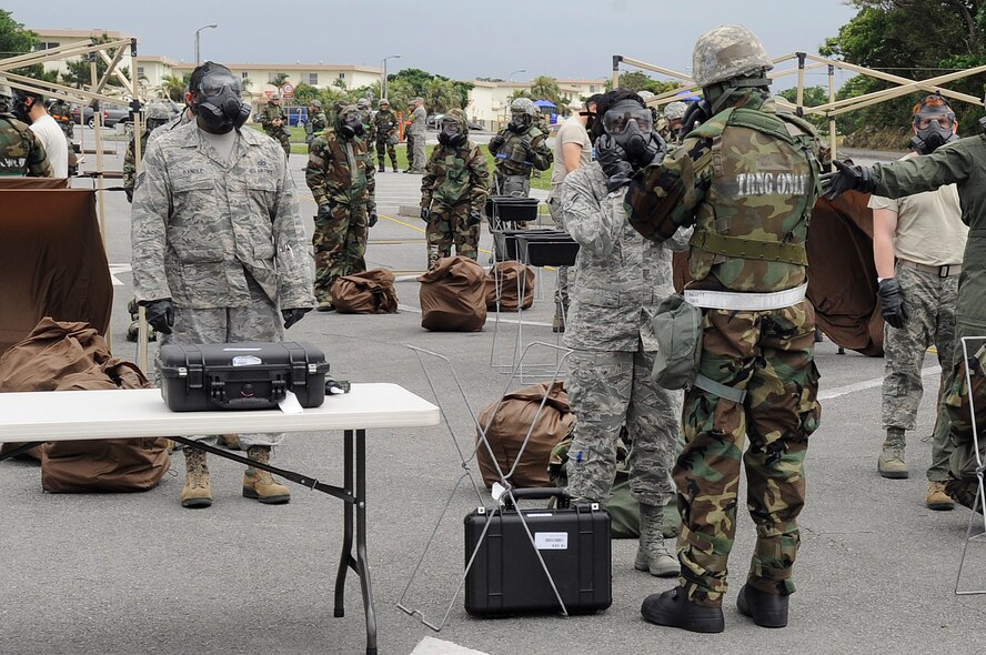 Airmen from the 18th Mission Support Group process through a contamination control area during Exercise Beverly High 15-2 on Kadena Air Base, Japan, April 22, 2015. A CCA consists of a hot zone, which is set up on the border of a contaminated area, a warm zone where Airmen are being decontaminated, and a cold zone which is a decontaminated area. (U.S. Air Force photo by Staff Sgt. Marcus Morris)