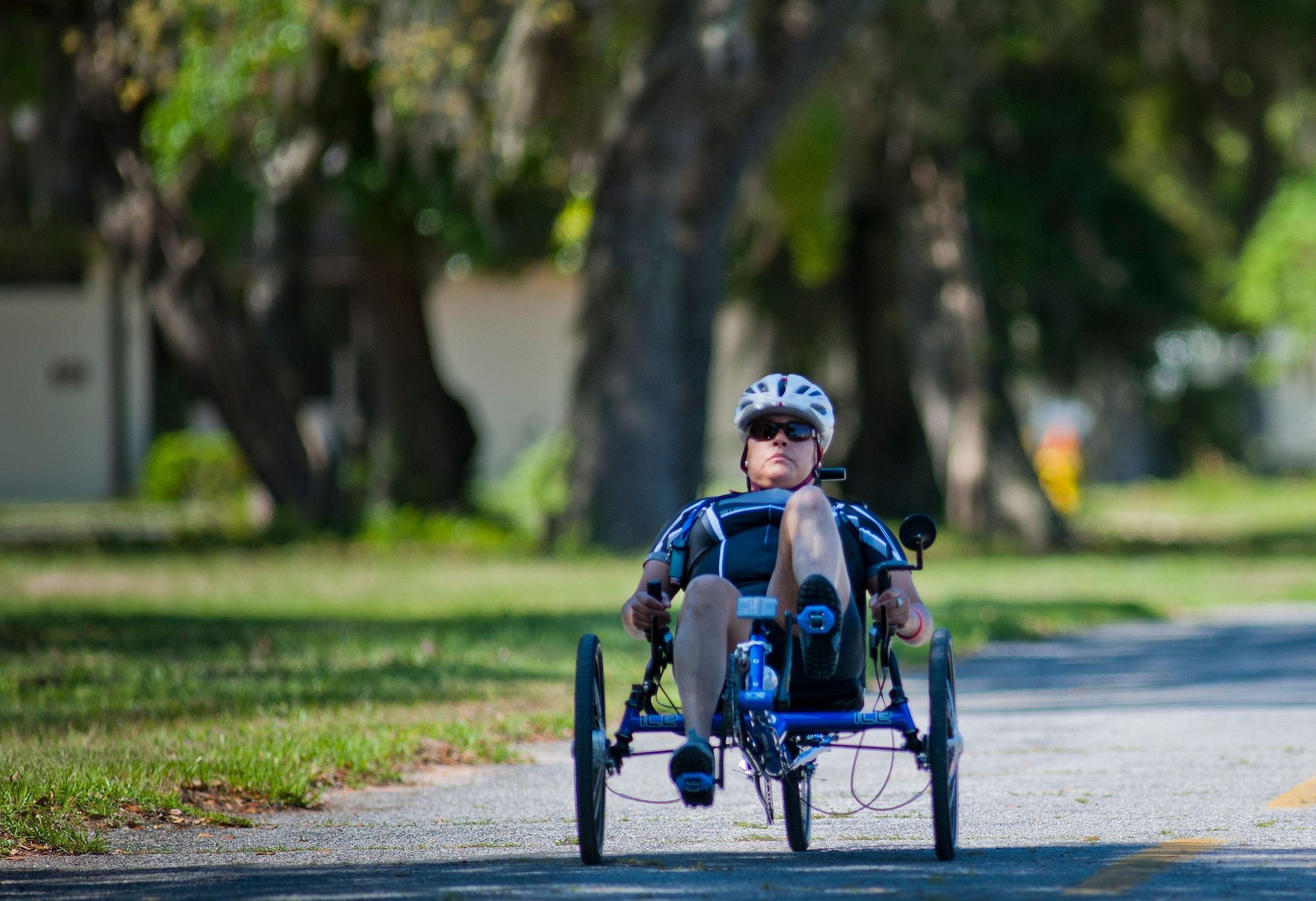 Mary McGriff, an Air Force Wounded Warrior athlete, peddles through a tree-covered road during the fourth day of the Warrior Games training camp at Eglin Air Force Base, Fla., April 21. The five-day training camp for the Air Force’s athletes serves as their last practice session before the Warrior Games June 19-28. (U.S. Air Force photo/Samuel King Jr.)