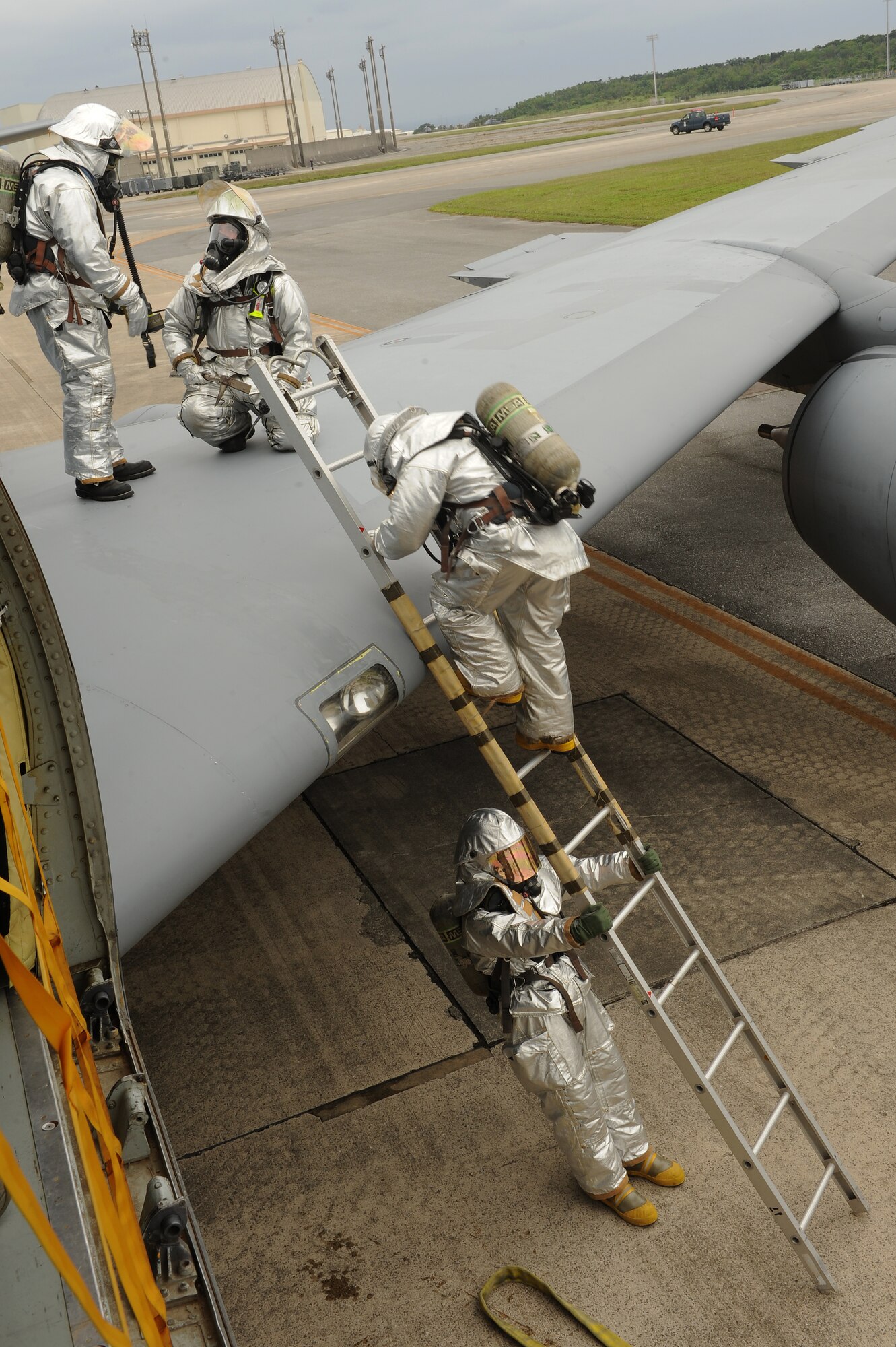 U.S. Air Force firefighters from the 18th Civil Engineer Squadron safely exit a KC-135 Stratotanker by ladder following the completion of a simulated on-board fire scenario on Kadena Air Base, Japan, April 21, 2015. The simulated fire was executed in support of the base’s mission focused exercise, and was designed to test the firefighters’ response time and knowledge of procedures. (U.S. Air Force photo by Airman 1st Class Zade C. Vadnais)