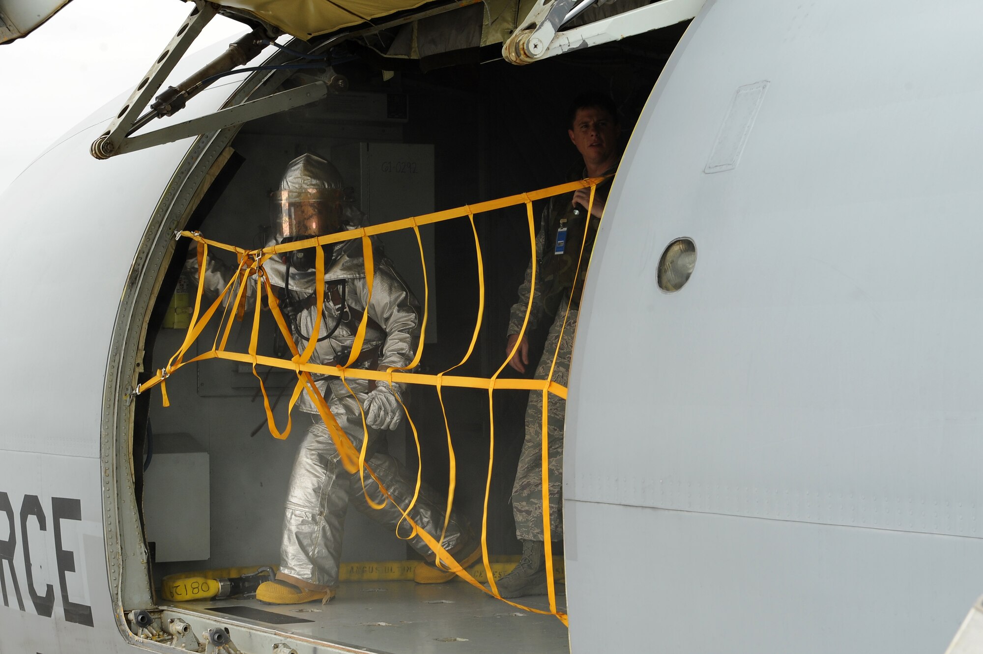 U.S. Air Force Staff Sgt. Tye Reed, 18th Civil Engineer Squadron fire protection crew chief, opens an oversized cargo door on a KC-135 Stratotanker in order to clear smoke from inside the cabin during an exercise on Kadena Air Base, Japan, April 21, 2015. The scenario, which involved firefighters responding to reports of an aircraft with smoke from its cockpit, was held in support of the base’s mission focused exercise, and tested firefighters’ response time and knowledge of procedures. (U.S. Air Force photo by Airman 1st Class Zade C. Vadnais)