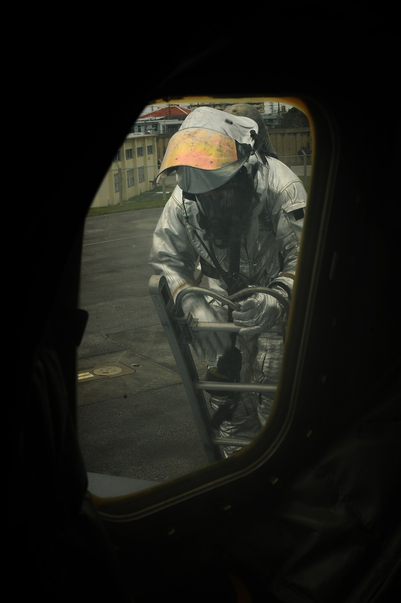 U.S. Air Force Staff Sgt. Corey Woods, 18th Civil Engineer Squadron firefighter, climbs onto the wing of a KC-135 Stratotanker in order to put out an on-board simulated fire on Kadena Air Base, Japan, April 21, 2015. The scenario, which involved firefighters responding to reports of smoke coming from an aircraft’s cockpit, was held in support of the base’s mission focused exercise, and was designed to test their response time and knowledge of procedures. (U.S. Air Force photo by Airman 1st Class Zade C. Vadnais)