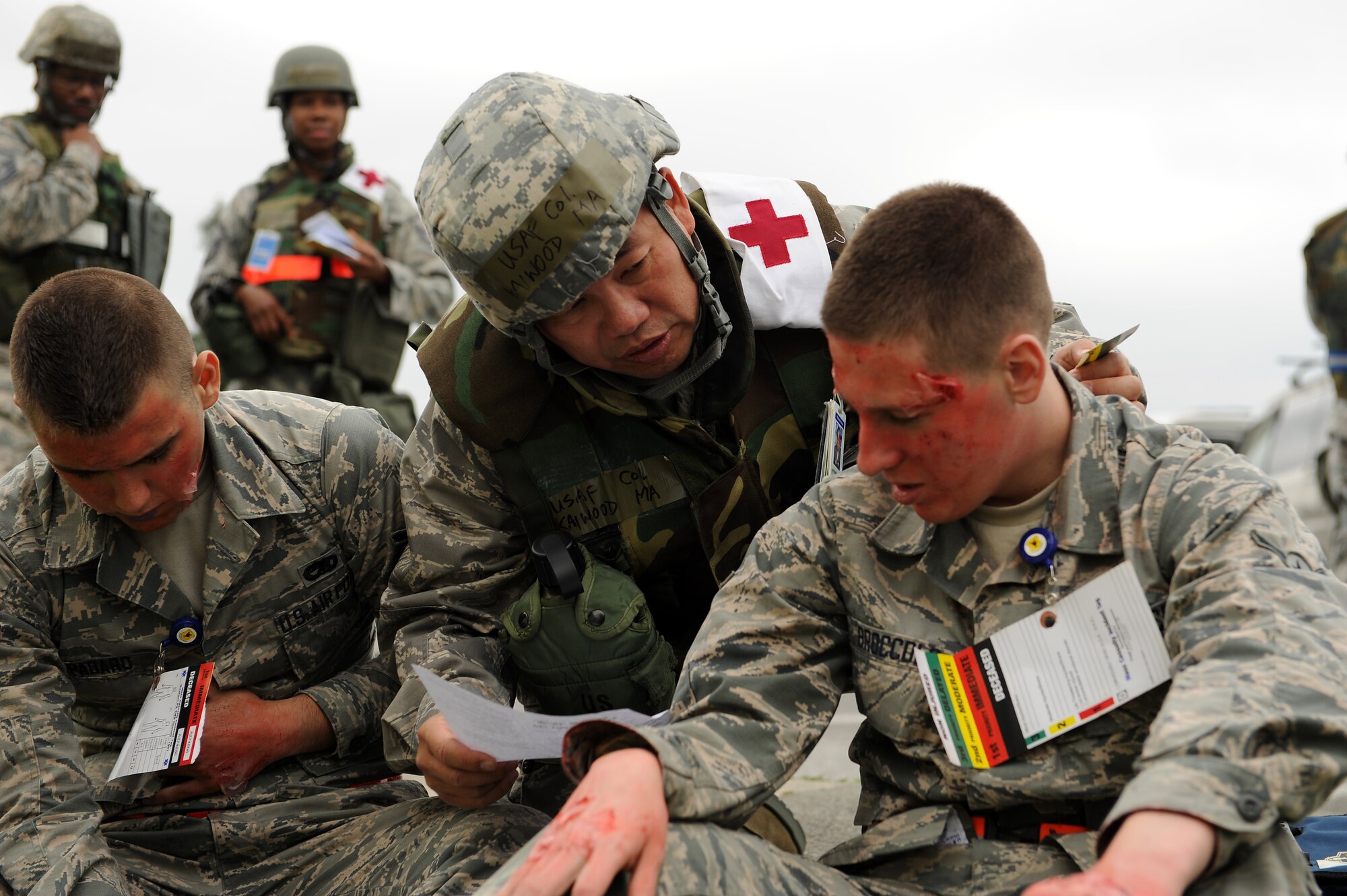 U.S. Air Force Col. Kaiwood Ma, 18th Medical Group chief of aerospace medicine, assesses the simulated injuries of Airmen Jack Spadaro and Nicholas Broccolo, 18th Component Maintenance Squadron aerospace propulsion technicians, following a simulated vehicle accident on Kadena Air Base, Japan, April 21, 2015. The scenario involved a chemical transportation truck becoming involved in a vehicle accident, injuring the personnel inside and dousing them with chemicals. Once the chemicals were contained, medical staff arrived on the scene to transport simulated victims to a medical facility. (U.S. Air Force photo by Airman 1st Class Zade C. Vadnais)