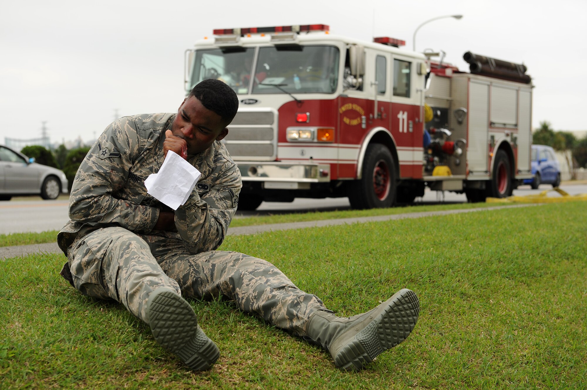 U.S. Air Force Airman Antonio Osborne, 718th Aircraft Maintenance Squadron weapons armament technician, pretends to be injured while waiting to be transported to a medical facility on Kadena Air  Base, Japan, April 21, 2015. Osborne and other Airmen from around the base donned stage makeup and pretended to be injured in order to test the readiness of the 18th Wing’s first responders. (U.S. Air Force photo by Airman 1st Class Zade C. Vadnais)