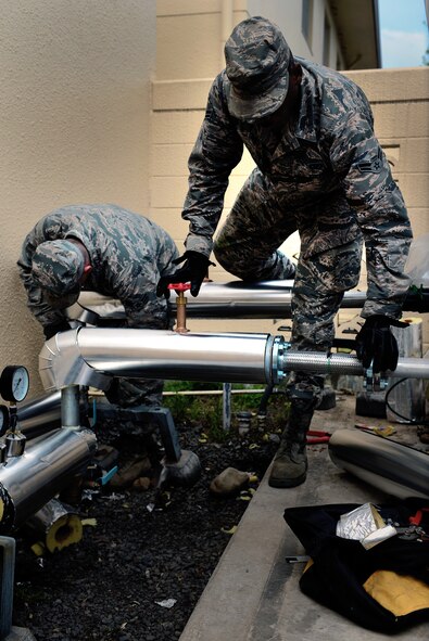 374th Civil Engineer Squadron Heating Ventilation and Air Conditioning Airmen install insulation and shielding for pipes April 21, 2015 at Yokota Air Base, Japan. Their task was part of the larger goal of installing a new chiller for a building. (U.S. Air Force photo by Airman 1st Class Delano Scott/Released)