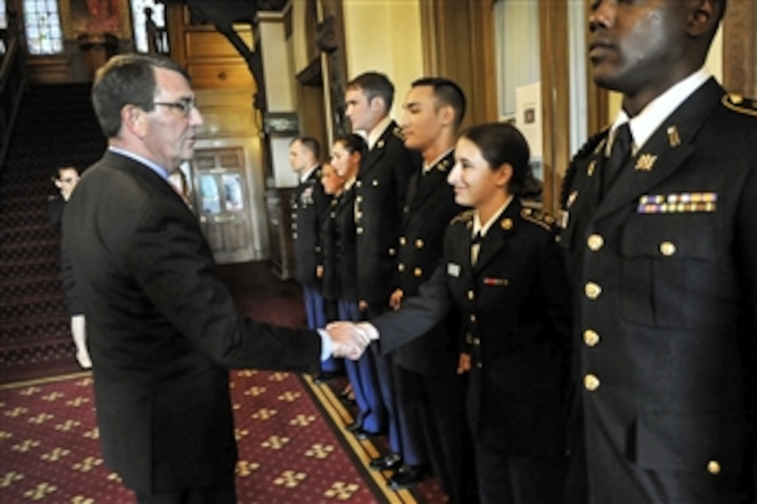 Defense Secretary Ash Carter shakes hands and gives his personal coin to ROTC members after delivering remarks on the Defense Department's efforts regarding sexual assault prevention and response at Georgetown University in Washington, D.C., April 22, 2015. 