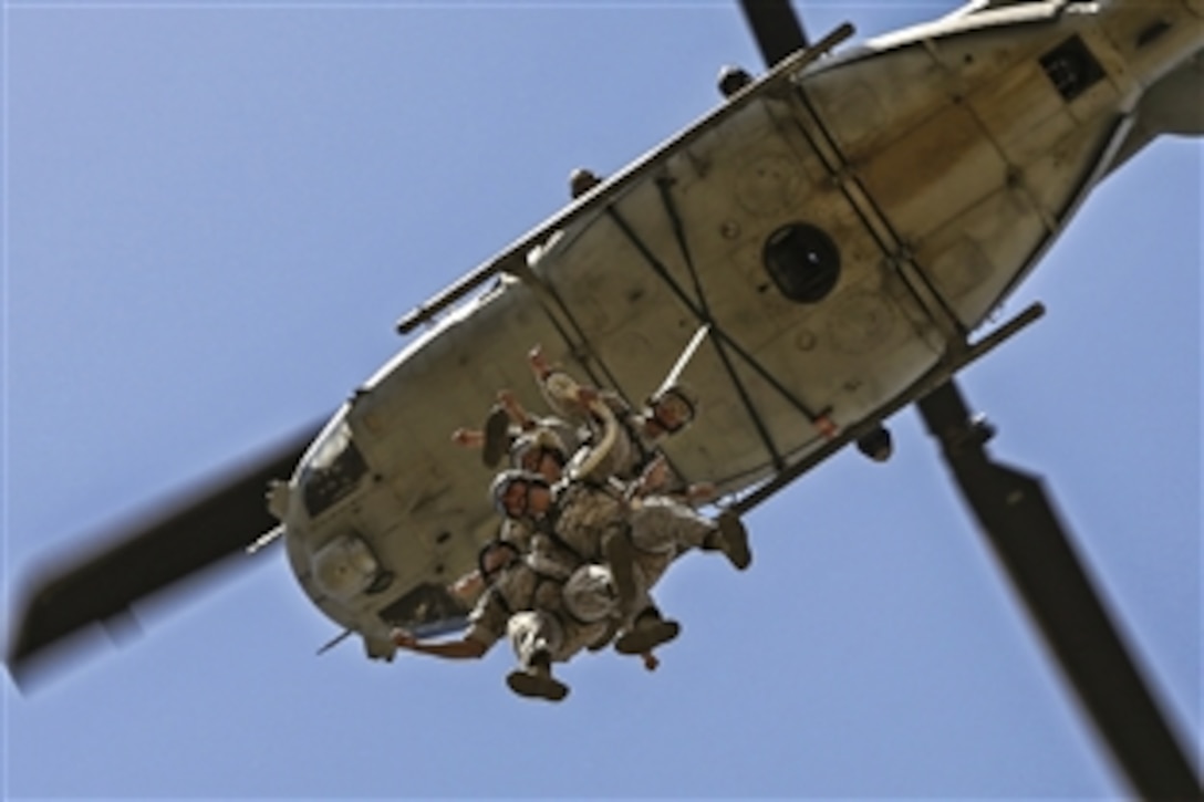 A helicopter hoists Marines into the air during insertion and extraction training on Camp Pendleton, Calif., April 17, 2015. The Marines are students of the Basic Reconnaissance Course assigned to Reconnaissance Training Company.
