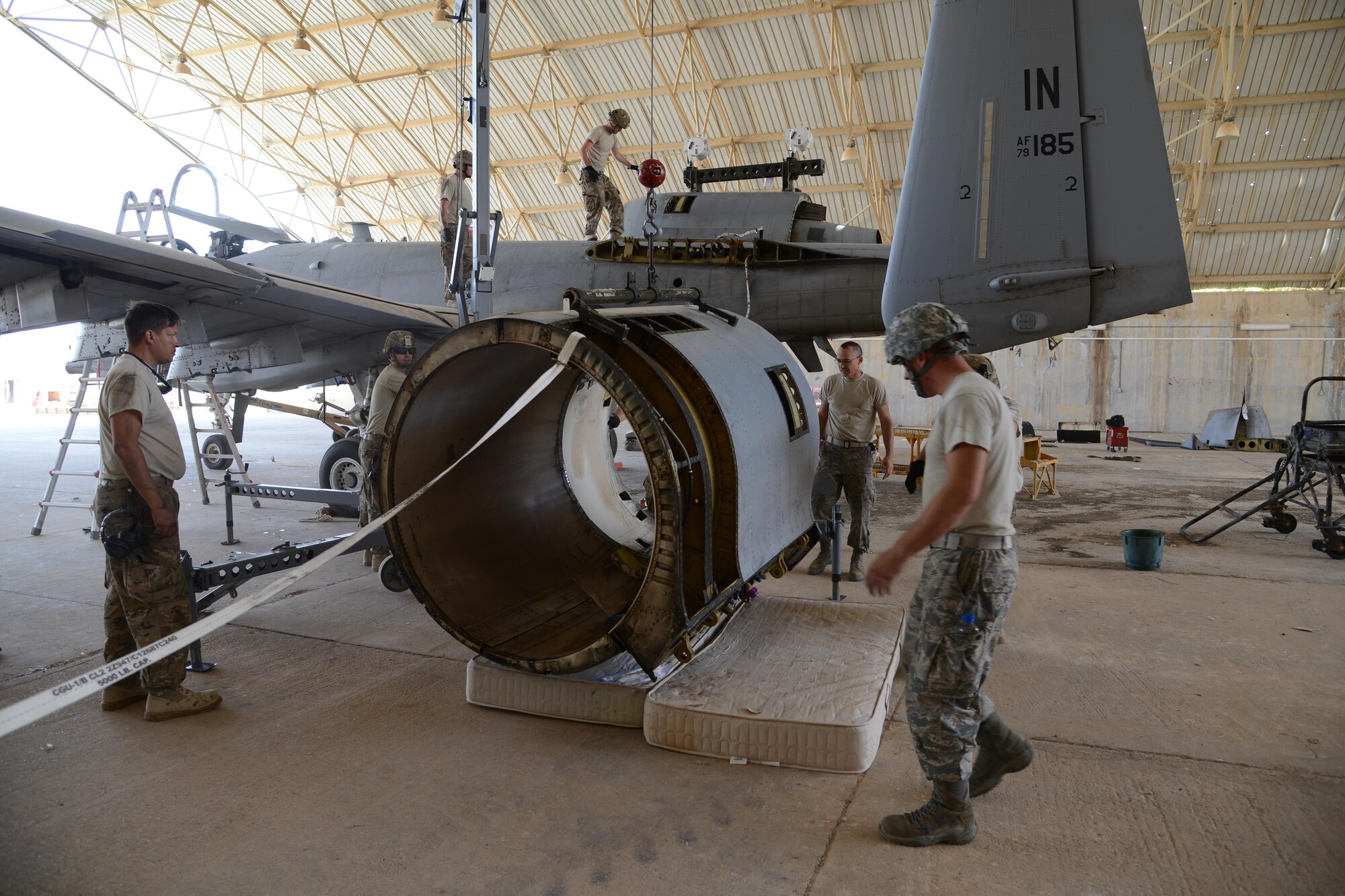 Airmen from the 332nd Expeditionary Maintenance Squadron remove a damaged nacelle, the protective covering on the engine, from an A-10C Thunderbolt II at Al Asad Air Base, Iraq. A maintenance response team from the 332nd EMXG repaired the jet and got it back in the air in less than five days after the jet suffered catastrophic engine failure and had to divert there. (U.S. Air Force photo by Tech. Sgt. Jared Marquis/released)