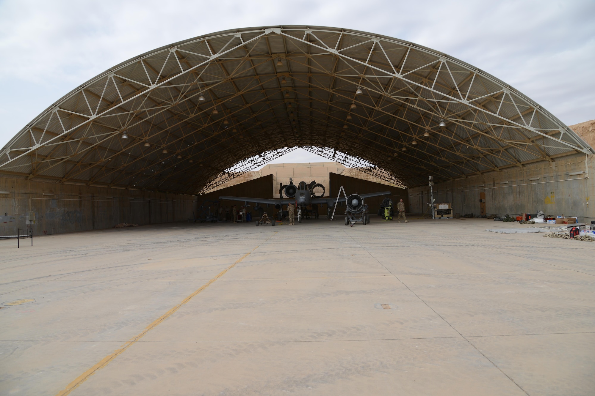 Airmen from the 332nd Expeditionary Maintenance Squadron work in an abandoned aircraft shelter at Al Asad Air Base, Iraq to repair an A-10C Thunderbolt II that suffered catastrophic engine failure. A maintenance response team from the 332nd EMXG repaired the jet and got it back in the air less than five days after the jet suffered catastrophic engine failure and had to divert there. (U.S. Air Force photo by Tech. Sgt. Jared Marquis/released)