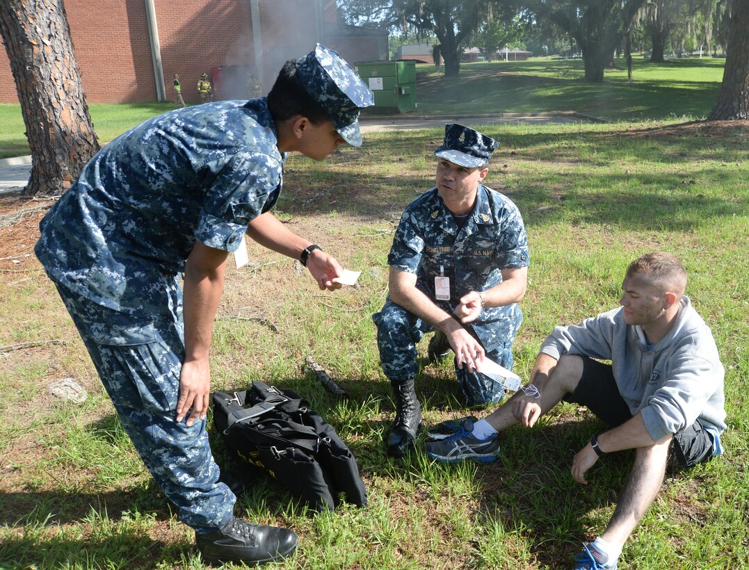 Sailors from the Naval Branch Health Clinic, Albany, located at Marine Corps Logistics Base Albany, assist installation firefighters/emergency medical technicians in triaging and treating active-duty service members for burns, smoke inhalation and other injuries as a result of a fire at the Base Theater. The simulated incident was in conjunction with the Raging Renegade active-shooter exercise held, here, April 21.