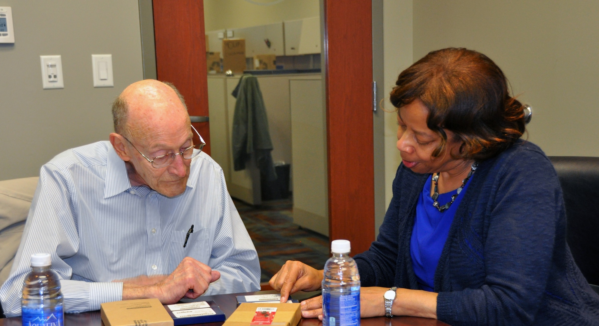 Former 1st Lt. Clayton A. Nattier, a veteran bomber pilot who was held as a prisoner of war during World War II, goes over the medals he received from the Air Reserve Personnel Center with Jacqueline Bing, sustainment division chief, April 17, 2015, on Buckley Air Force Base, Colo. Nattier visited ARPC to receive his POW Medal among various other medals, then took time to personally meet and thank the members on the recognition service team who assisted him. Along with Bing, other members from the ARPC recognition service team who assisted Nattier are: retired Brig. Gen. Pat Quisenberry, evaluations branch chief, Master Sgt. Jeremy Bohn, pre-trained individual manpower division chief, and Master Sgt. Richard Grybos, NCO in charge of training and development. Nattier worked in conjunction with retired Lt. Col. Kathryn Wirkus, a constituent service representative from U.S. representative Ed Perlmutter’s staff, to attain his POW Medal. A formal presentation to award the POW Medal to Nattier is currently being planned by U.S. representative Ed Perlmutter’s office. (U.S. Air Force photo/Tech. Sgt. Rob Hazelett)