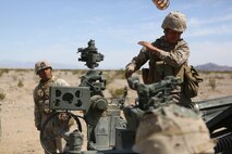 Lance Cpl. Tyler S. Griffith, a field artillery cannoneer with Battery A, 1st Battalion, 11th Marine Regiment, 1st Marine Division, discards a charge sleeve after loading charges during Exercise Desert Scimitar 2015 aboard Marine Corps Air Ground Combat Center Twentynine Palms, Calif., April 20, 2015. The tough, realistic live-fire training central to Desert Scimitar allows Division units to train in order to maintain readiness and meet current and real-world operational demands.