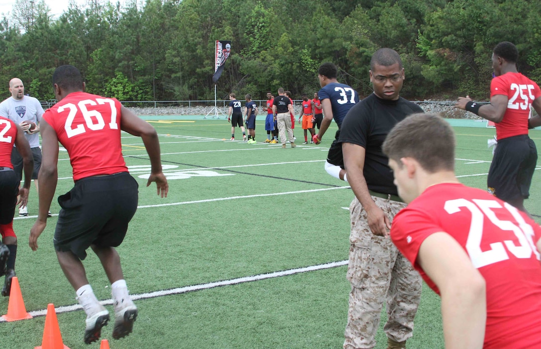 U.S. Marine Corps Staff Sgt. Damien Green, a recruiter with Recruiting Station Raleigh and native of District Heights, Maryland, leads an agility drill during the Raleigh Semper Fidelis Football Camp at Cardinal Gibbons High School in Raleigh, North Carolina, April 19, 2015. The one-day camp brought in close to 200 high school football players from North Carolina and Virginia to give them a chance to work with Marines and National Football League coaches. The Semper Fidelis Football Camps are taking place in 24 cities across the country to showcase the Marine Corps’ commitment to developing quality citizens and highlight how Marine Corps values of honor, courage and commitment relate to success both on and off the field.  (U.S. Marine Corps photo by Sgt. Dwight A. Henderson/Released) 