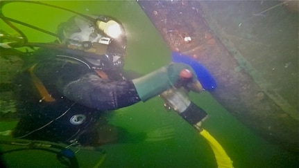 150416-N-IJ355-002 BOSTON (April 16, 2015) - A diver from Supervisor of Salvage and Diving performs hull cleaning on USS Constitution, the U.S. Navy's oldest active ship.