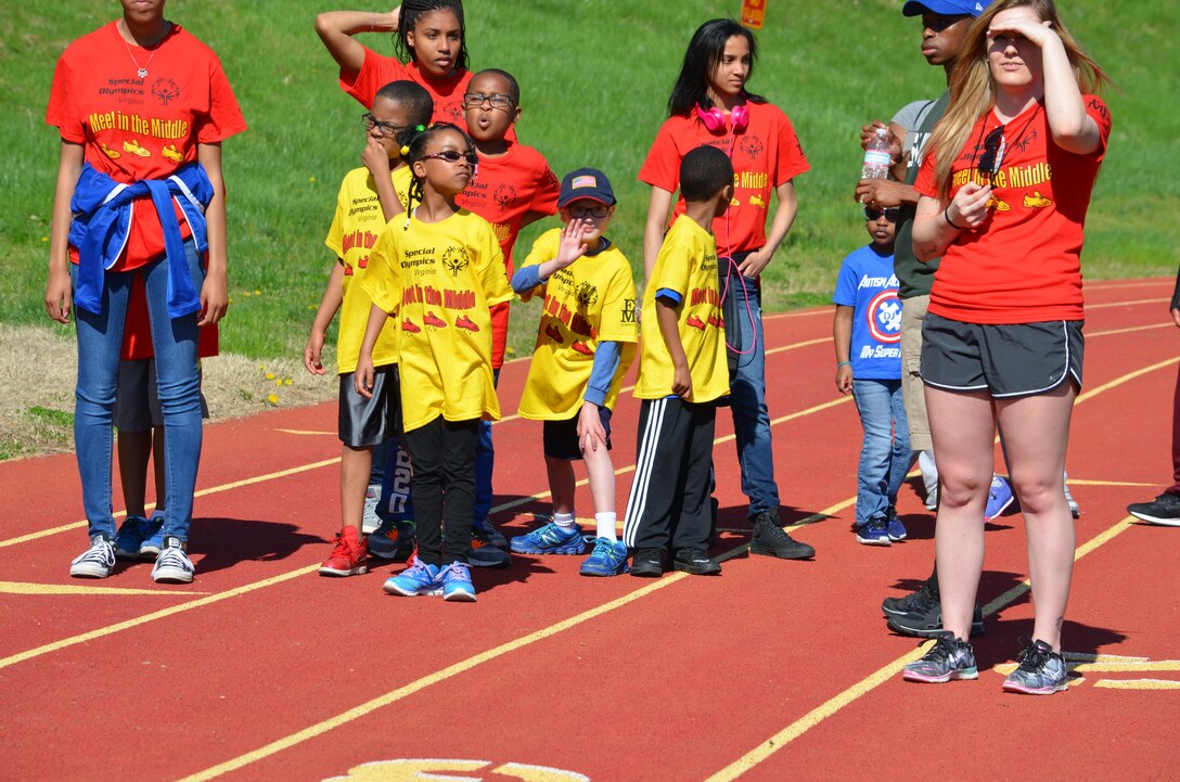 Special Olympics athletes and their buddies line up at the start of the 50-meter sprint during the “Meet in the Middle” held at Butler Stadium Saturday. Boys and girls of all ages and ability levels participated in the noncompetitive event, with all earning a dog tag-style medal and a snow cone at the end of the morning.