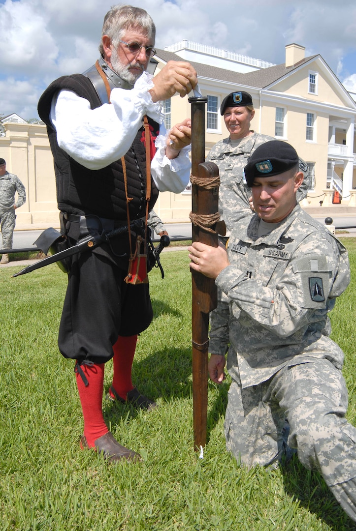 Historical re-enactor John Cipriani show Florida National Guard Soldiers how to load a "hand gonne" - a primitive portable cannon - in front of the historic St. Francis Barracks during a celebration in St. Augustine, Fla., Sept. 16, 2010, in recognition of the 445th anniversary of the 'first muster' of citizen-soldiers in Spanish-Florida.