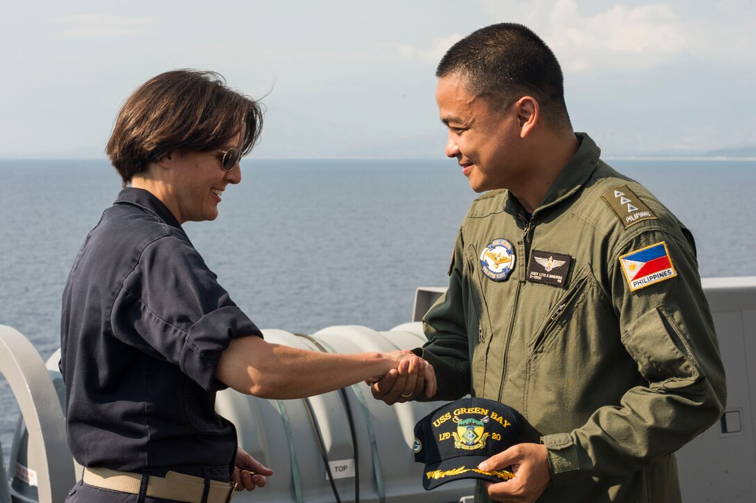 Capt. Kristy McCallum, commanding officer of the amphibious transport dock ship USS Green Bay (LPD 20), greets Philippine navy, Lt. Senior Grade Joey Marayag on the ship's starboard bridge wing during exercise Balikatan 2015. Green Bay is part of the Bonhomme Richard Amphibious Ready Group, and with the embarked 3rd Marine Expeditionary Force Forward, is currently participating in exercise Balikatan 2015, an annual, bilateral exercise conducted with the Armed Forces of the Philippines.