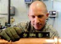 Tech. Sgt. Kristopher Dolehanty, 341st Civil Engineering Squadron NCO in charge of heating ventilating and air conditioning, checks to make sure piping for the base swimming pool heater is level April 21, 2015, at Malmstrom Air Force Base, Mont. Dolehanty was recently selected to attend the Tri-Service Physician Assistant Training program. He has one year left in HVAC until he starts the PA program.(U.S. Air Force photo/Staff Sgt. Delia Marchick)