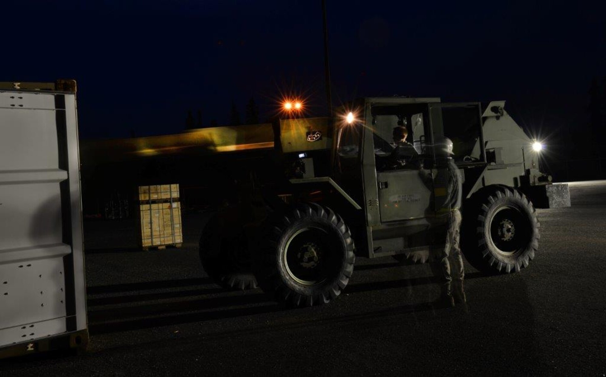 The first load of the ammunition containers arrive on Joint Base Elmendorf-Richardson April 15. Contracted forklift operators use their skills to unload each container weighing between 20,000 and 40,000 pounds. After they are offloaded from the trucks, the ammunition inspection team standing by opens the containers and inspects the ammunition before storing them into earth-covered igloos. (U.S. Air Force Photo/Airman 1st Class Kyle Johnson)