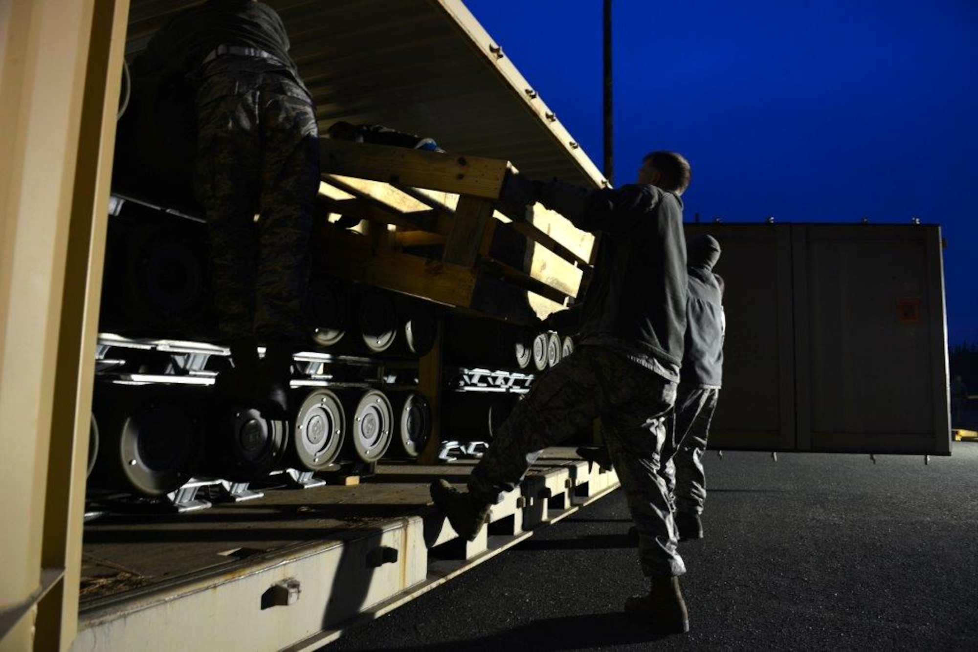The first load of the ammunition containers arrive on Joint Base Elmendorf-Richardson April 15. Contracted forklift operators use their skills to unload each container weighing between 20,000 and 40,000 pounds. After they are offloaded from the trucks, the ammunition inspection team standing by opens the containers and inspects the ammunition before storing them into earth-covered igloos. (U.S. Air Force Photo/Airman 1st Class Kyle Johnson)