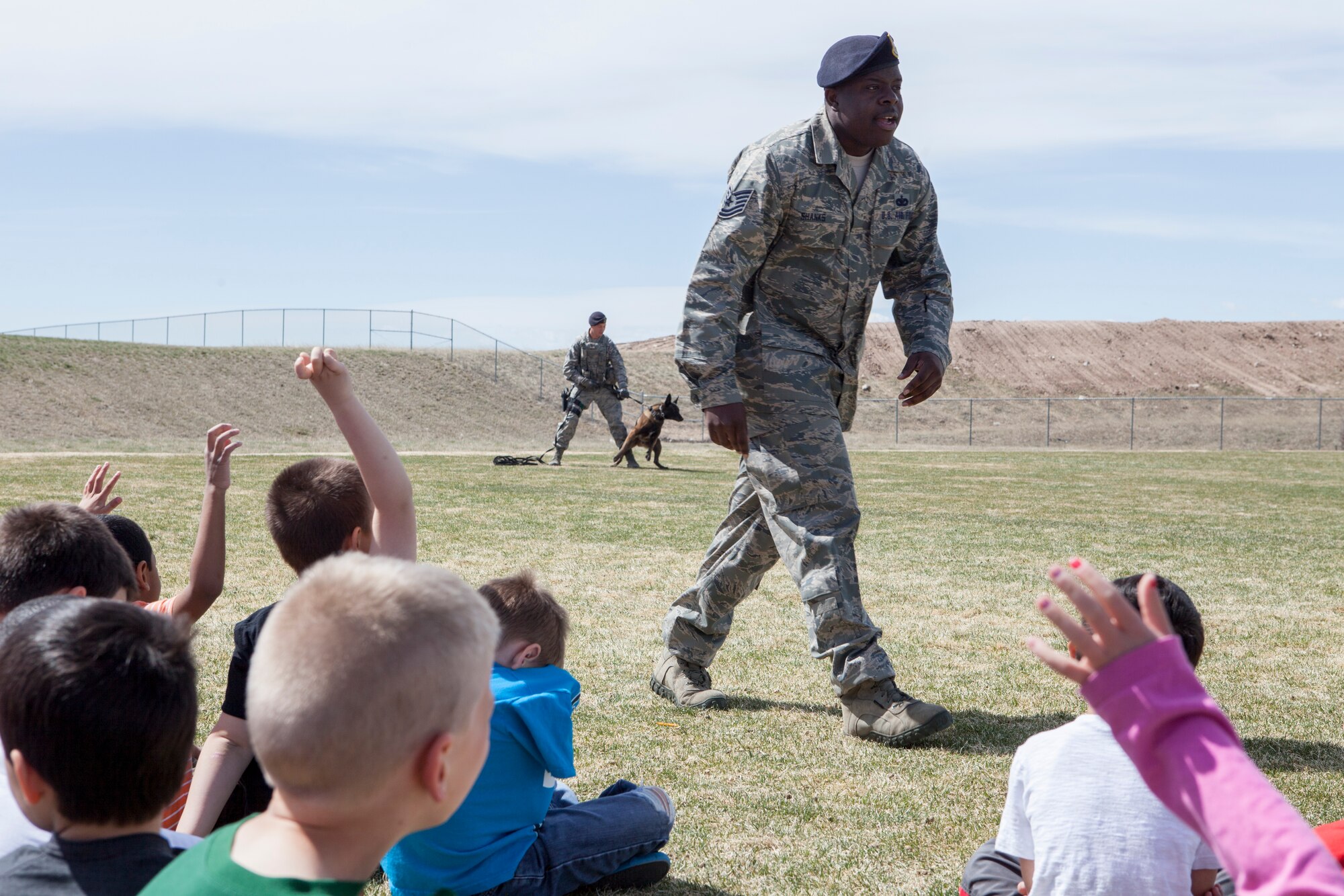 Tech. Sgt. Zerrick Shanks, 90th Security Forces Squadron military working dog trainer, addresses students at Freedom Elementary School, Cheyenne, Wyo., April 21, 2015. Ninetieth SFS's K-9 unit demonstrated tactics and techniques for the students to familiarize them with the dogs' mission. Ninetieth SFS is stationed with 90th Missile Wing on F.E. Warren Air Force Base, Wyo. (U.S. Air Force photo by Lan Kim)

