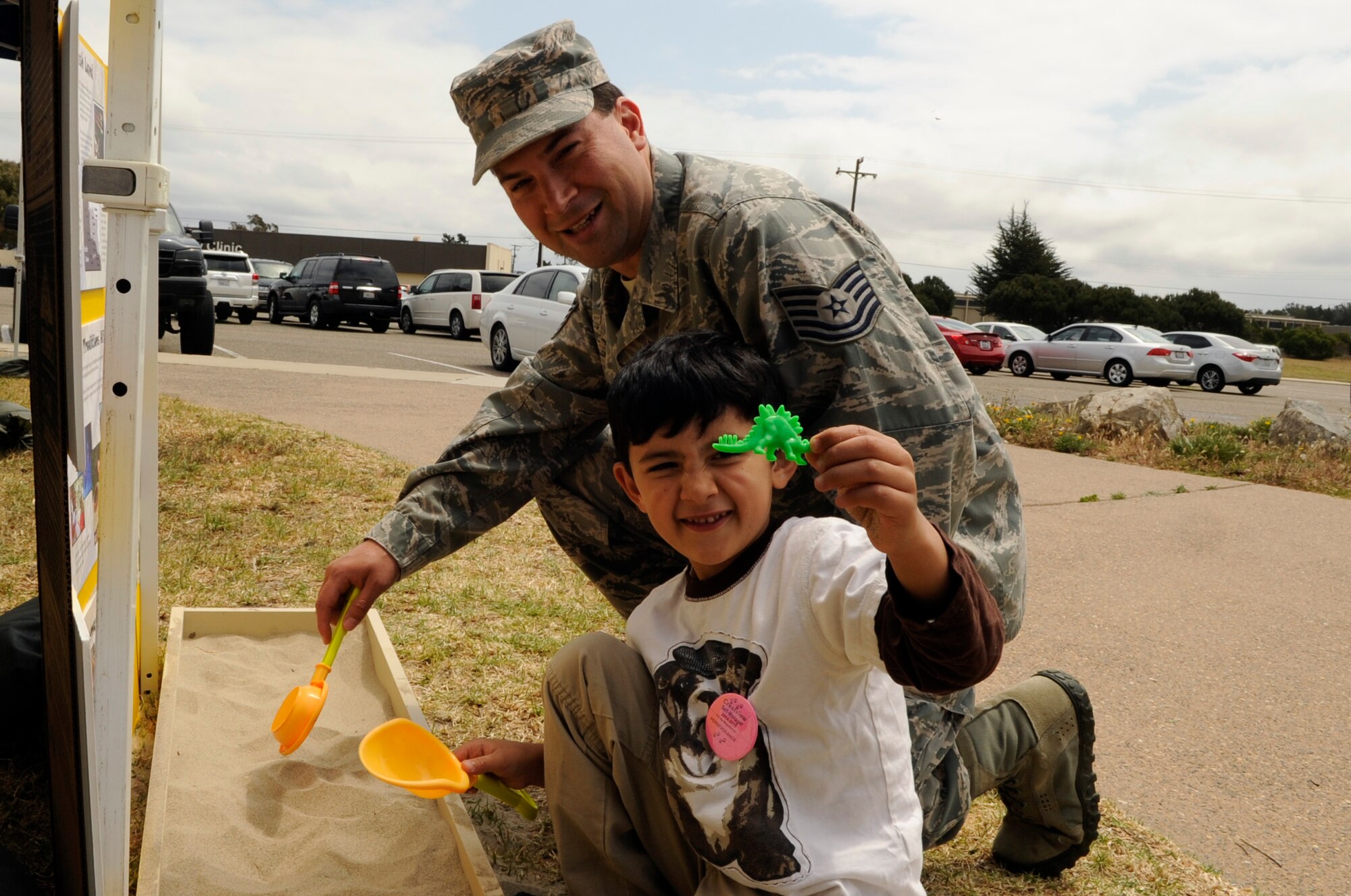 Tech. Sgt. Jamie Massaro, 30th Communications Squadron unit deployment manager, and his son Ryan, enjoy a hands-on exhibit during an Earth Day celebration, April 22, 2015, Vandenberg Air Force Base, Calif. The event was located in front of the base library and included various displays. (U.S. Air Force photo by Senior Airman Shane Phipps/Released)