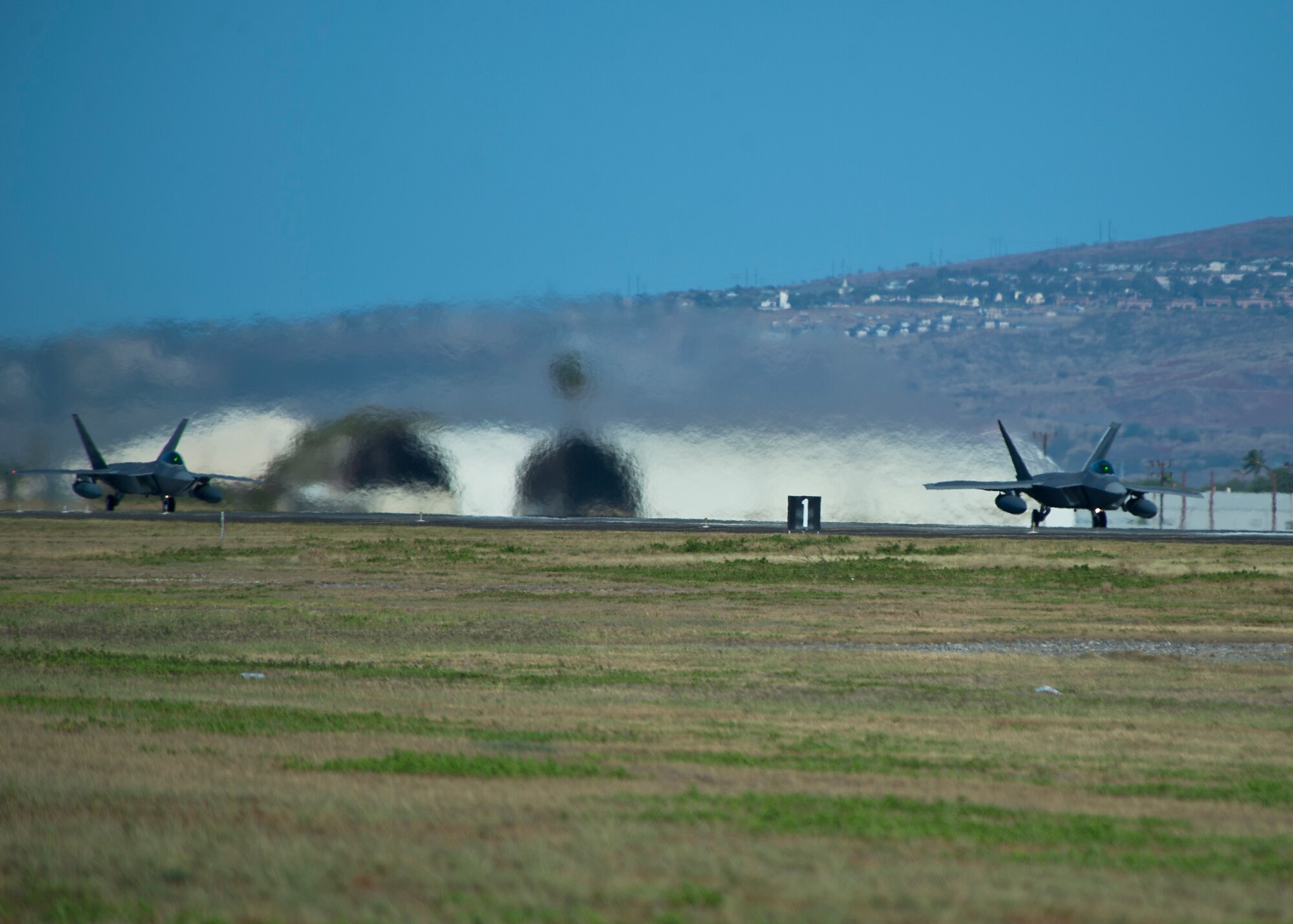 United States Air Force F-22 Raptors, from the Hawaiian Raptors, take-off from Joint Base Pearl Harbor-Hickam, Hawaii, April 20, 2015. The Hawaiian Raptors will fly 2,766 miles to Nellis Air Force Base NV, to take part in a joint training event. (U.S. Air Force photo by Tech. Sgt. Aaron Oelrich/Released)    