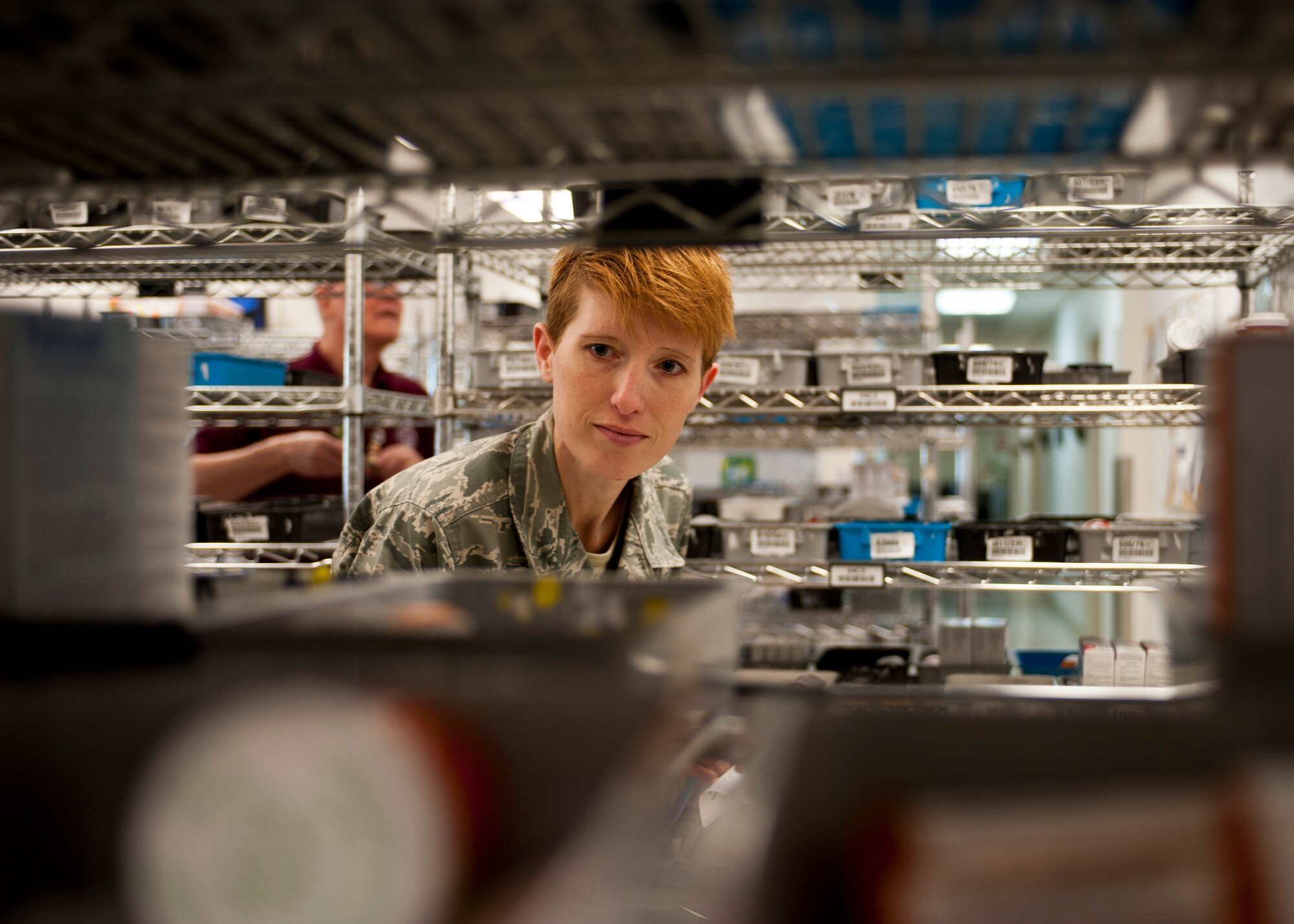Master Sgt. Alicia Walters, 99th Medical Support Squadron NCO in charge of the satellite pharmacy, searches for medication bins needed for a customer at Nellis Air Force Base, Nev., April 17, 2015. The bins are placed in the pick-up and delivery area where customers’ medications are waiting in advance of patients arriving to help reduce wait times. (U.S. Air Force photo by Airman 1st Class Jake Carter)