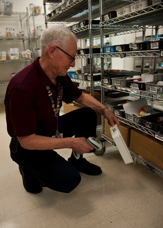James Duggins, volunteer at the satellite pharmacy, scans a bar code on a bin used for pharmacy supplies at Nellis Air Force Base, Nev., April 17, 2015. At the satellite pharmacy, civilians volunteer over 240 hours a week to help support operations and the overall health of patients. (U.S. Air Force photo by Airman 1st Class Jake Carter)