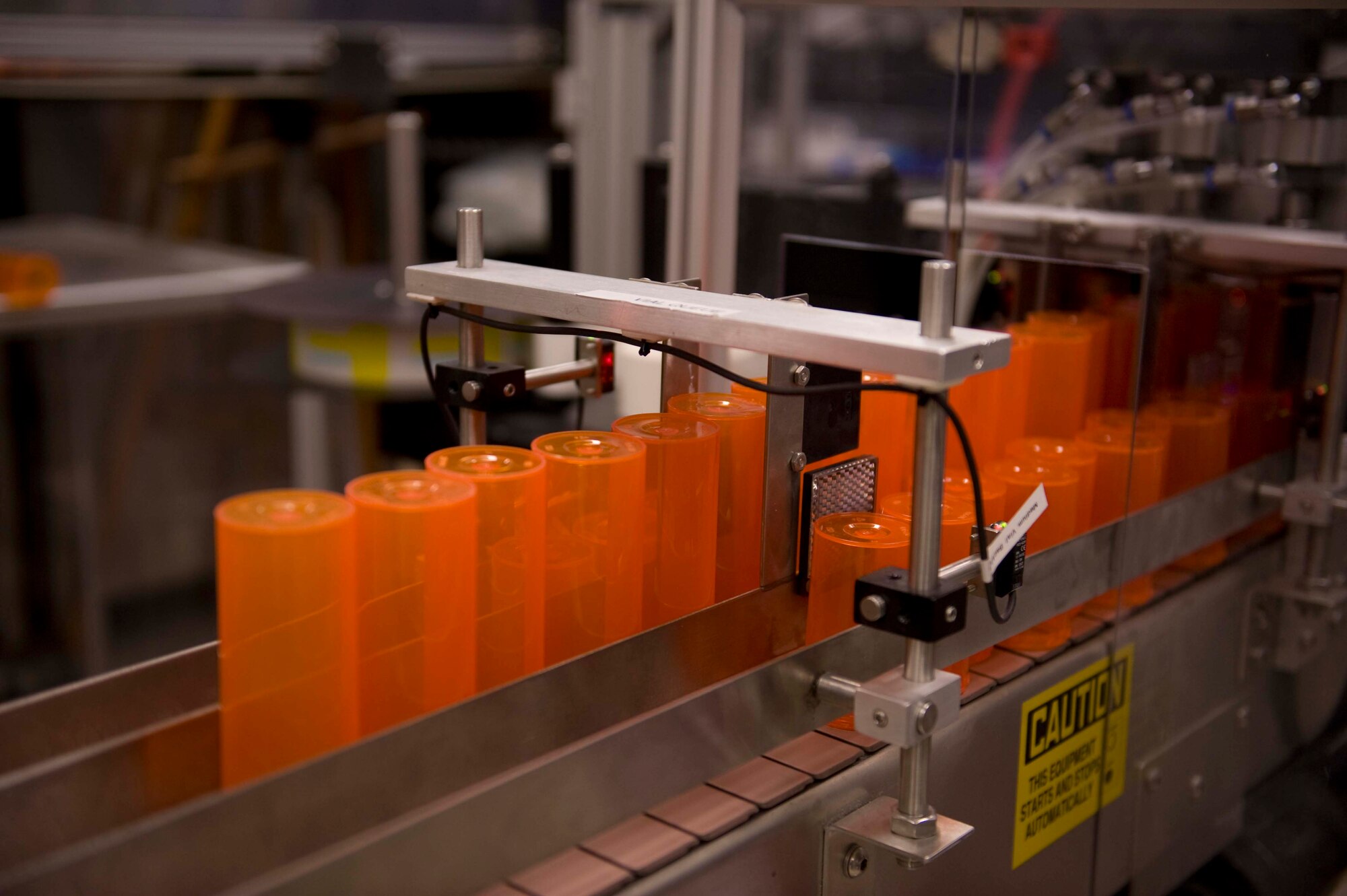 Medicine bottles sit on a conveyor belt at the satellite pharmacy on Nellis Air Force Base, Nev., April 17, 2015. The medicine bottles are separated into tall and short bottles. When a bottle is needed it is transported through a tube where “Robby”, a robotic dispensing system, will utilize them to refill prescriptions. (U.S. Air Force photo by Airman 1st Class Rachel Loftis)