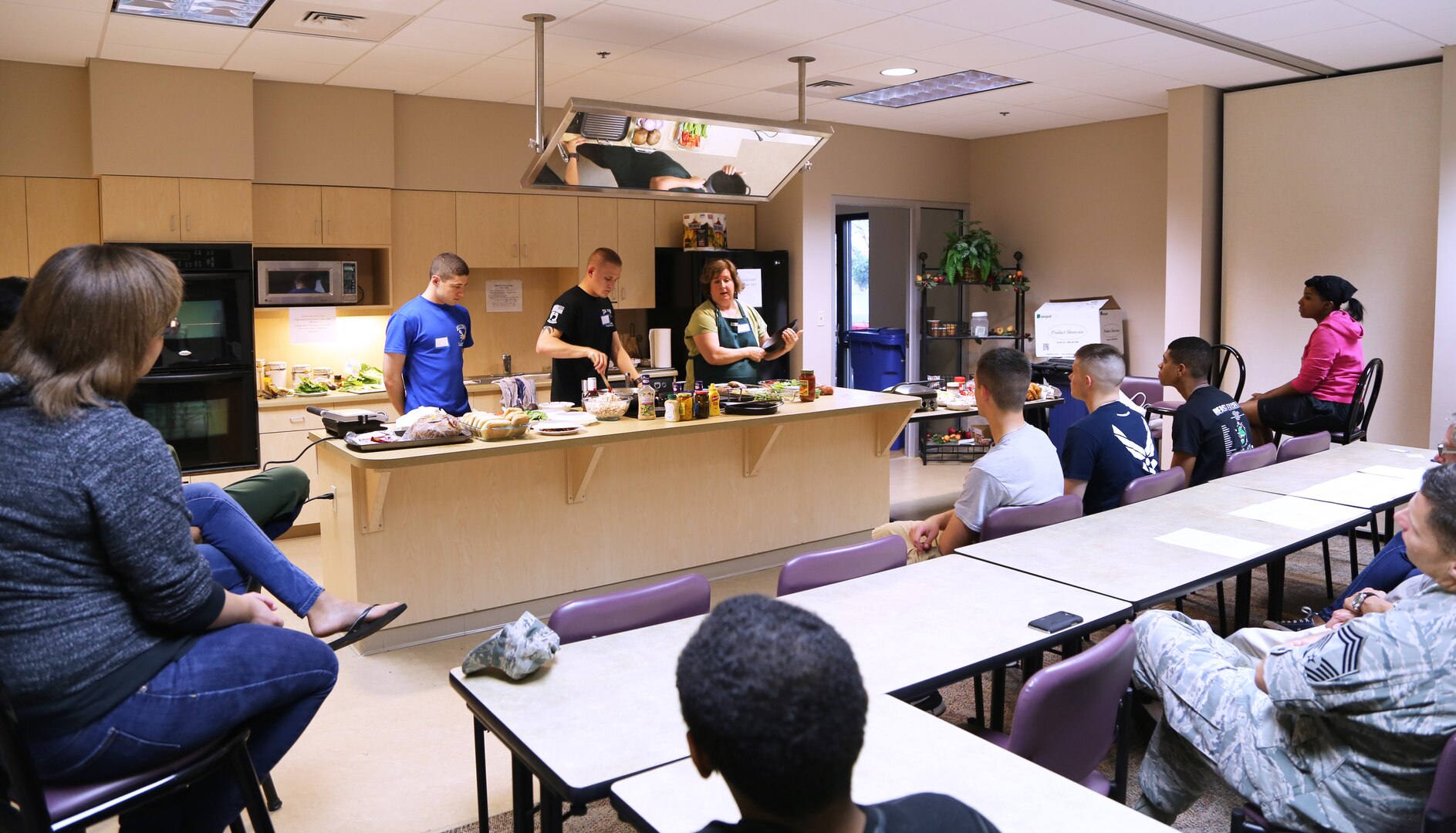 (Editor's note: For security reasons, the last names of remotely piloted aircraft operators have been withheld.)
Left to right: Airman John and Airman Dylan, 558th Flying Training Squadron Basic Sensor Operator Course students, follow instructions on how to prepare ingredients for a panini sandwich from Dianna Ackerley, military spouse and volunteer culinary instructor, during a "Dorm to Gourm" cooking class April 16 at the Joint Base San Antonio-Randolph Human Performance Resource Center. The class is one of a series to provide Airmen with culinary skills to potentially cook their own meals while the JBSA-Randolph Rendezvous Dining Facility is closed for renovation for about six months starting June 1. (U.S. Air Force photo by Airman 1st Class Alexandria Slade)

