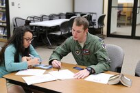 Elisabeth Gonzales (left), daughter of Chief Master Sgt. Terry Best-Rennahan, receives chemistry tutoring from Capt. Christopher Umphres, 435th Fighter Training Squadron instructor pilot, April 14 at the Joint Base San Antonio-Randolph library. Tutoring is offered 6-7 p.m. each Tuesday and Thursday at the library. For more information, call 652-5578 or 652-2617. (U.S. Air Force photo by Airman 1st Class Alexandria Slade)
